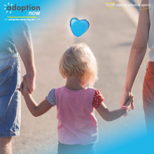 adopted child holding the hand of their adoptive parents as they walk in the evening sun
